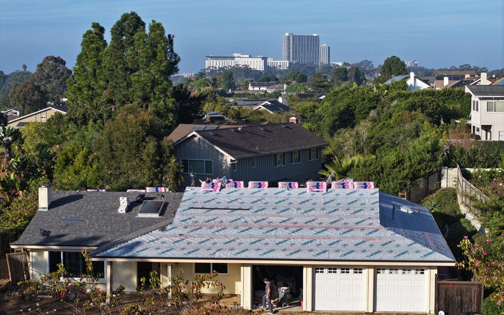 Roof Replacement in La Jolla at La Jolla Heights on Cliffridge Nailing down new asphalt shingles during a reroofing project by a premier roofing contractor La Jolla.
