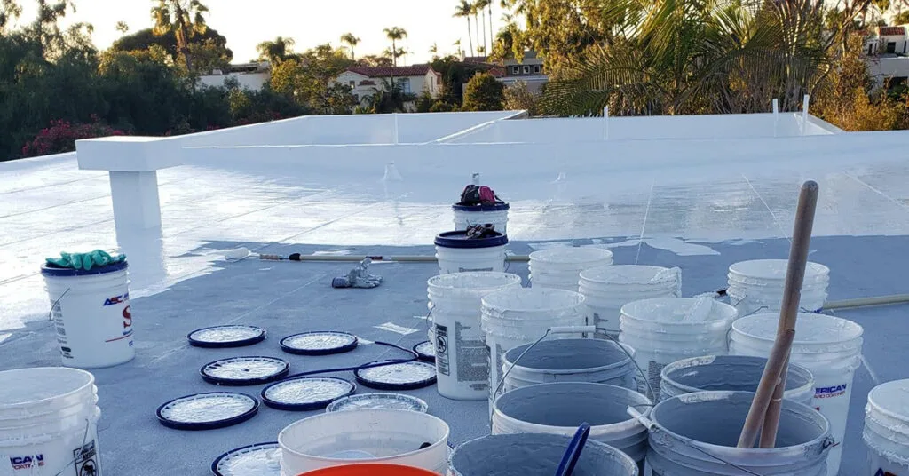 Kearny Mesa Roofing Contractor A Richardson Roofing team member applies a protective silicone coating to a commercial flat roof during a restoration project in Kearny Mesa.